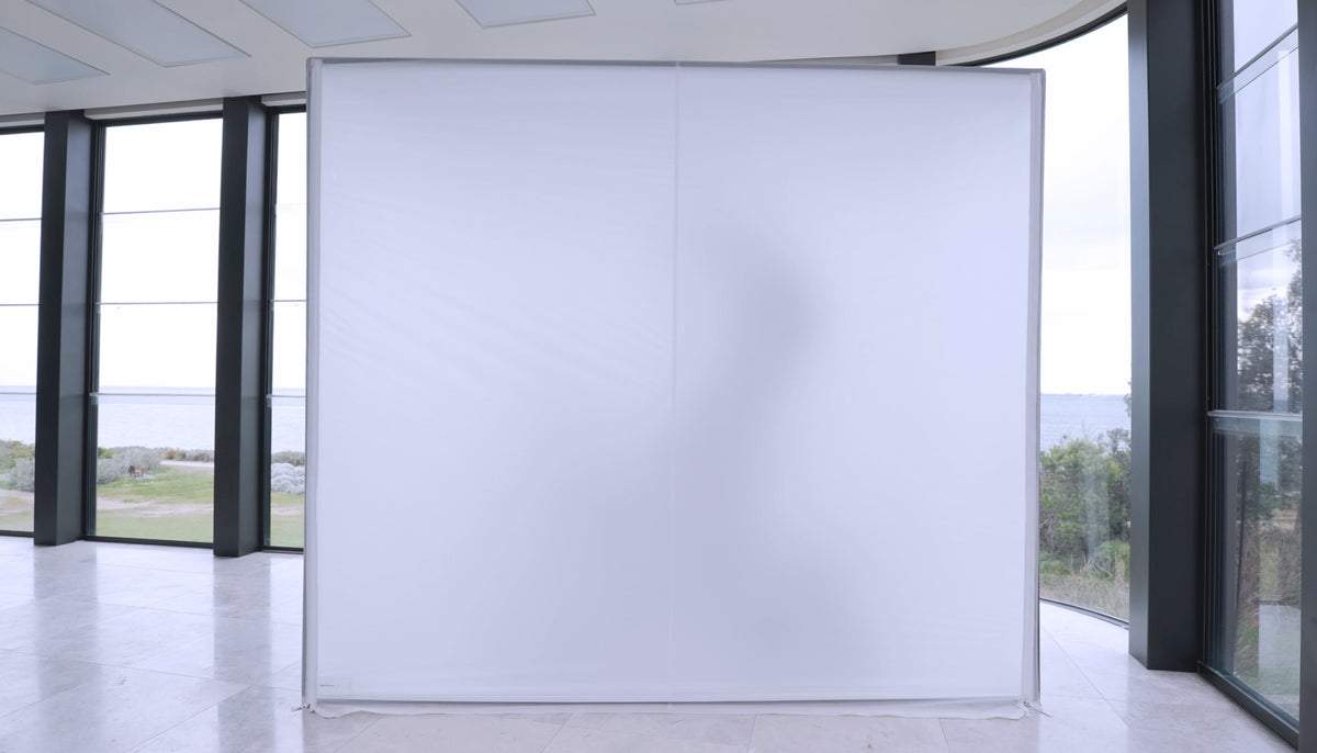 Enclosure closed up as a plain white wall, with a person's silhouette showing through the fabric
